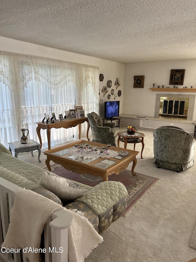 living room featuring carpet, a textured ceiling, and a fireplace