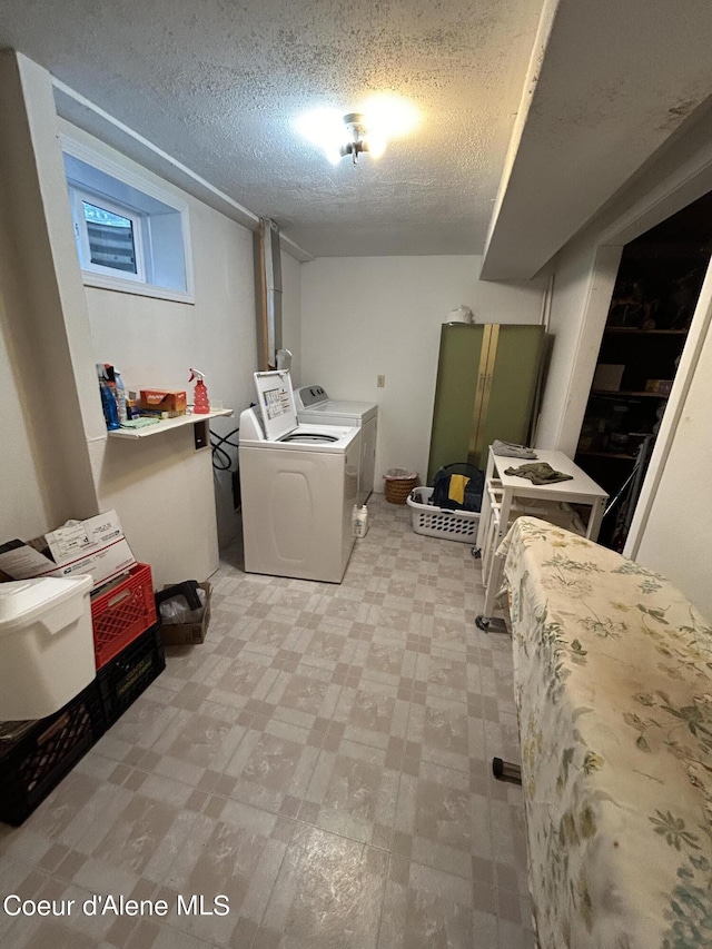 washroom featuring washing machine and clothes dryer and a textured ceiling