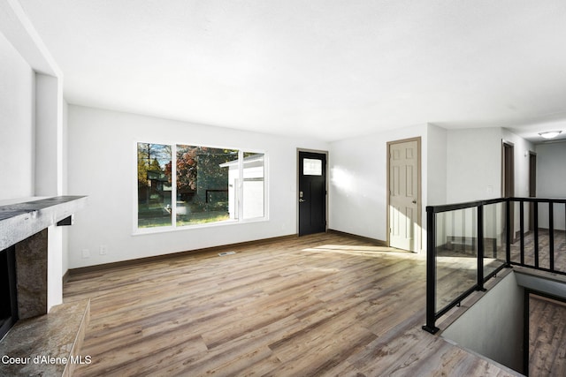 unfurnished living room with a premium fireplace and light wood-type flooring