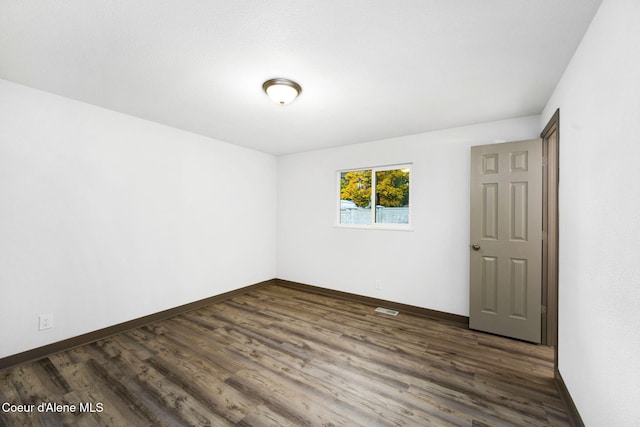 spare room with dark wood-type flooring