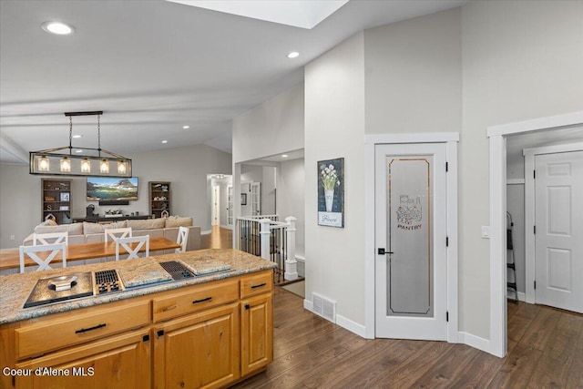 kitchen with pendant lighting, dark hardwood / wood-style floors, and vaulted ceiling with skylight