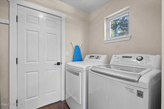 washroom featuring dark hardwood / wood-style floors and washing machine and clothes dryer