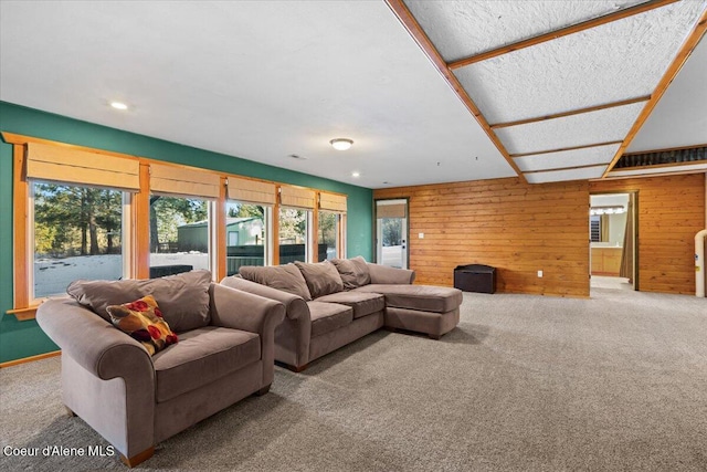 carpeted living room featuring wooden walls