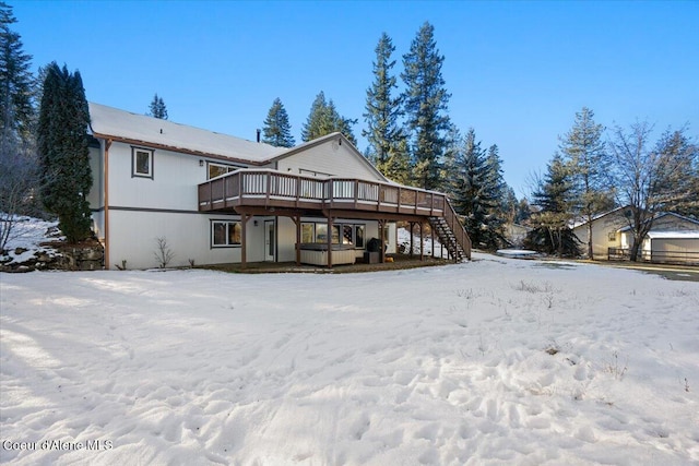 snow covered house with a wooden deck