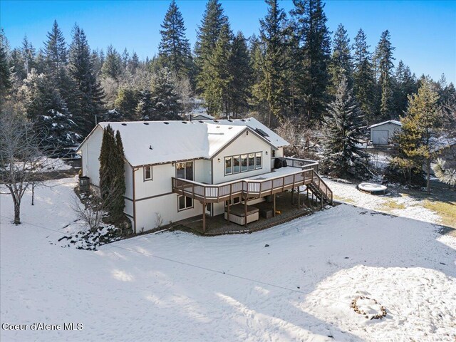 snow covered rear of property featuring a wooden deck