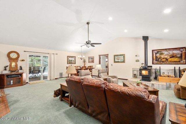 carpeted living room featuring ceiling fan, vaulted ceiling, and a wood stove