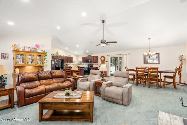 carpeted living room featuring ceiling fan with notable chandelier and vaulted ceiling