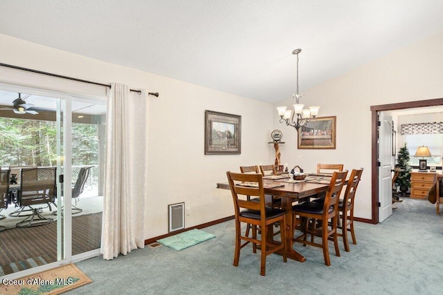 carpeted dining area featuring lofted ceiling and ceiling fan with notable chandelier