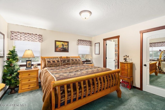 carpeted bedroom featuring multiple windows and a textured ceiling