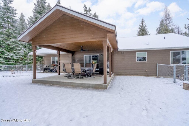 snow covered rear of property featuring a patio and ceiling fan