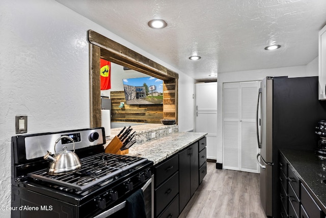 1715 Sherman Ave, Coeur Dalene, ID 83814 - kitchen featuring light hardwood / wood-style flooring, stainless steel refrigerator, light stone counters, a textured ceiling, and black range with gas stovetop