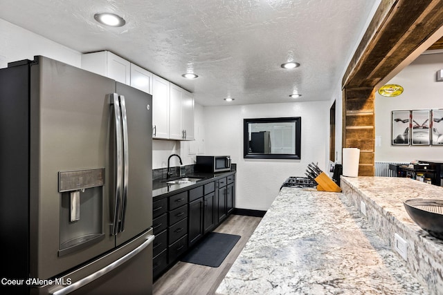 1715 Sherman Ave, Coeur Dalene, ID 83814 - kitchen with sink, white cabinetry, a textured ceiling, appliances with stainless steel finishes, and light hardwood / wood-style floors