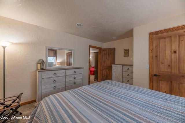 bedroom featuring carpet and a textured ceiling