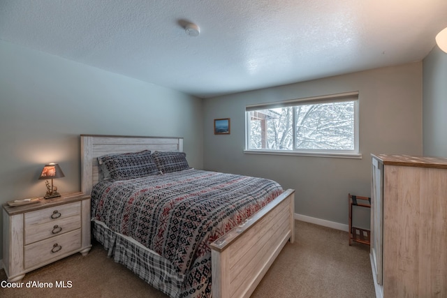 bedroom with light colored carpet and a textured ceiling