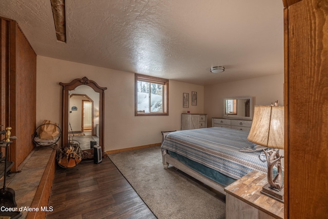 bedroom featuring a textured ceiling and dark hardwood / wood-style flooring