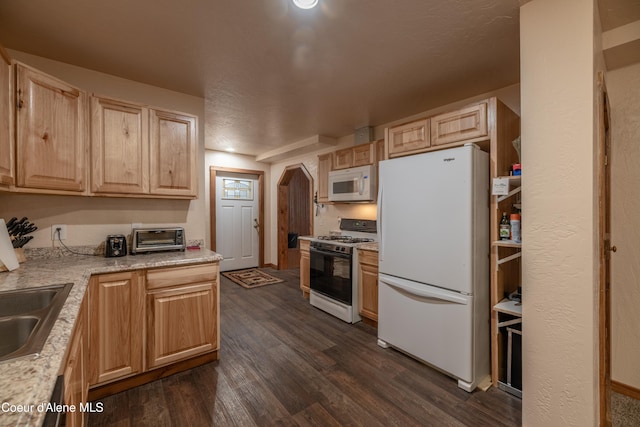 kitchen with dark wood-type flooring, white appliances, light brown cabinetry, and sink