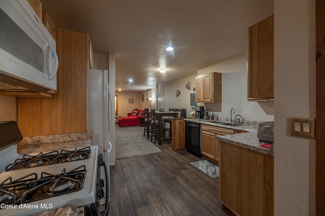 kitchen featuring white appliances, dark hardwood / wood-style floors, sink, and a textured ceiling