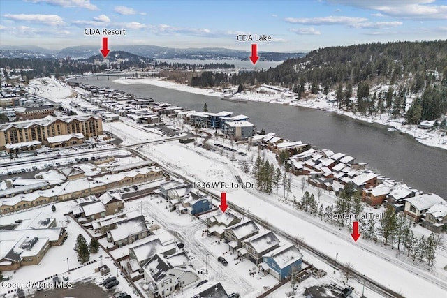 snowy aerial view with a water and mountain view