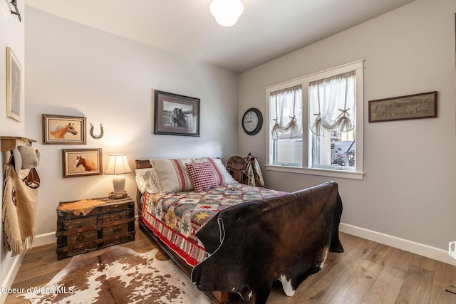 bedroom with wood finished floors and baseboards