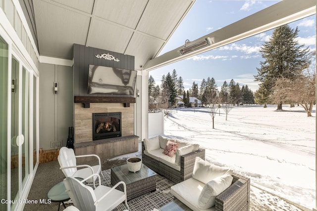 snow covered patio with an outdoor living space with a fireplace