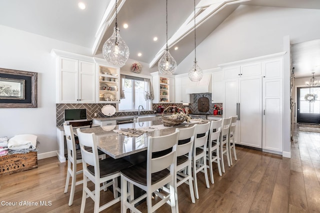 dining space featuring high vaulted ceiling, light wood finished floors, recessed lighting, and baseboards