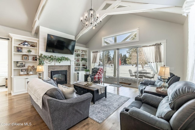 living area with beam ceiling, a fireplace, an inviting chandelier, light wood-style floors, and high vaulted ceiling