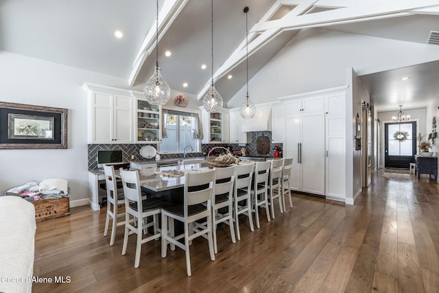 dining area featuring dark wood-style floors, visible vents, high vaulted ceiling, and beam ceiling