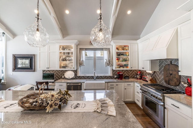 kitchen with decorative backsplash, appliances with stainless steel finishes, vaulted ceiling with beams, white cabinetry, and a sink