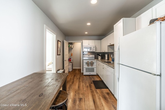 kitchen featuring white appliances, tasteful backsplash, white cabinets, and wood finished floors