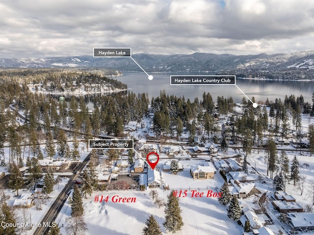 snowy aerial view featuring a water and mountain view