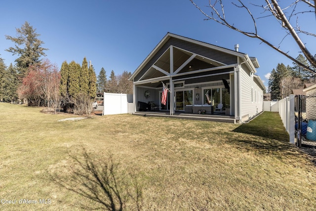 rear view of house with fence, a lawn, and a patio