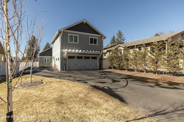 view of front facade with driveway, a garage, and board and batten siding