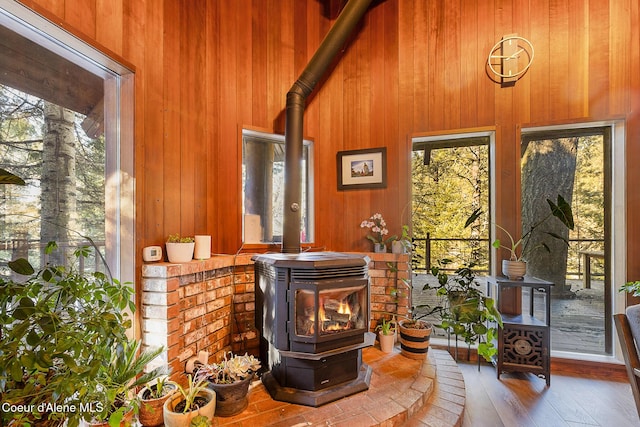 details featuring a wood stove, hardwood / wood-style floors, and wooden walls