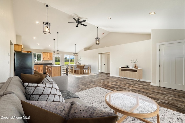 living room with baseboards, ceiling fan, dark wood-type flooring, high vaulted ceiling, and recessed lighting