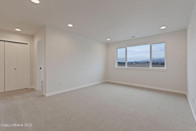 carpeted spare room with a textured ceiling