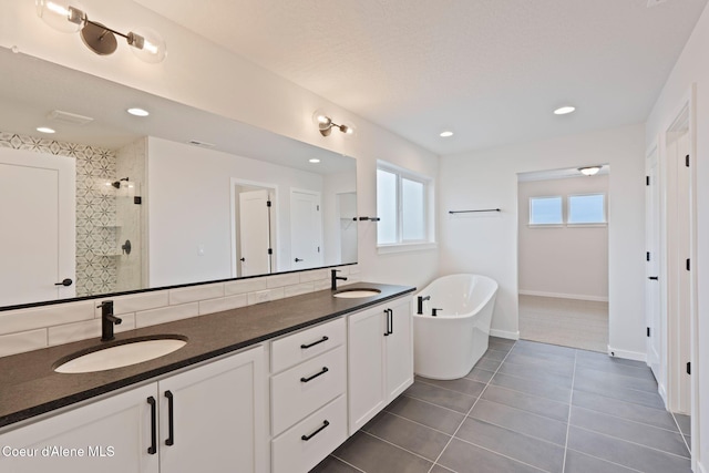 bathroom with independent shower and bath, vanity, and tile patterned floors