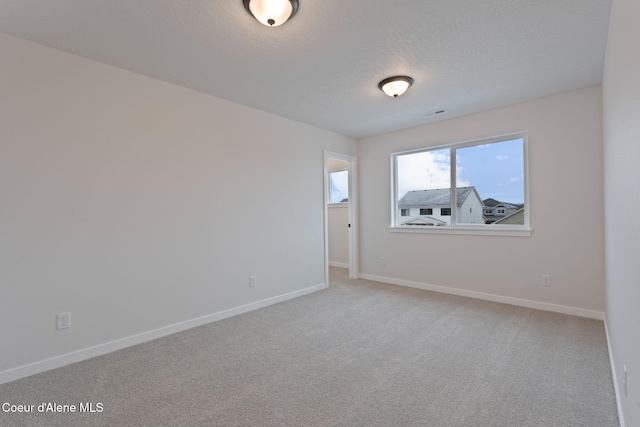 carpeted spare room featuring a textured ceiling