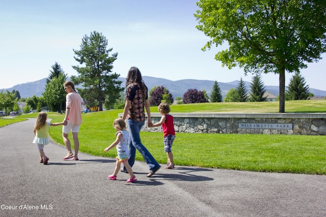 view of community featuring a mountain view and a lawn