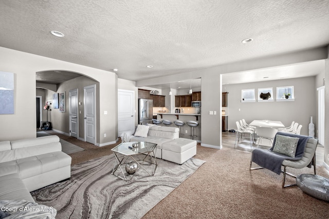 carpeted living room featuring a textured ceiling