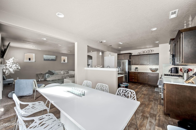 dining room with dark hardwood / wood-style floors and a textured ceiling