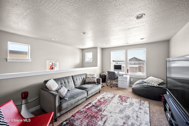 carpeted living room featuring a healthy amount of sunlight and a textured ceiling