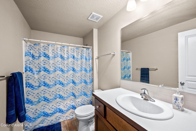 bathroom featuring toilet, wood-type flooring, a textured ceiling, vanity, and decorative backsplash