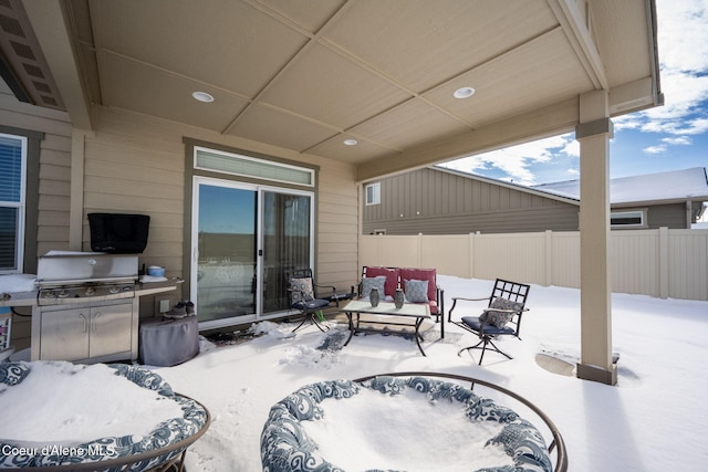 snow covered patio featuring a grill