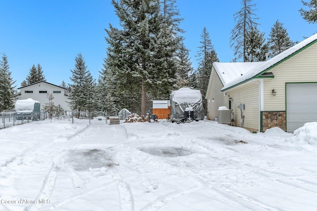 yard covered in snow featuring a garage