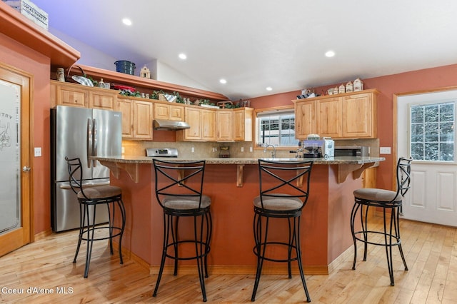 kitchen with stainless steel fridge, a center island, and stone counters