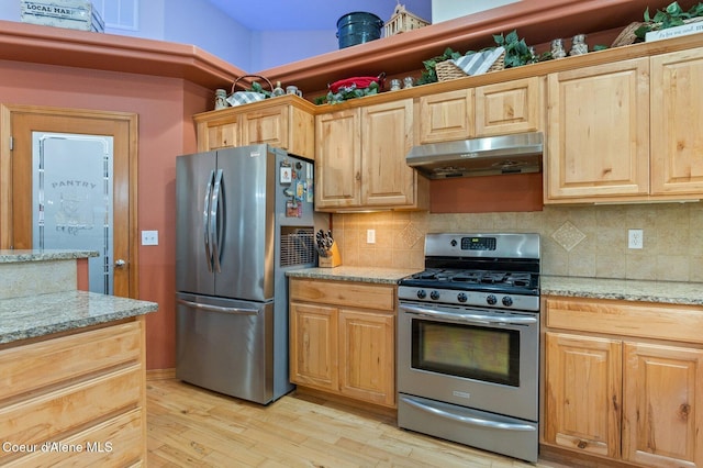 kitchen featuring light brown cabinetry, light stone counters, tasteful backsplash, light hardwood / wood-style flooring, and stainless steel appliances