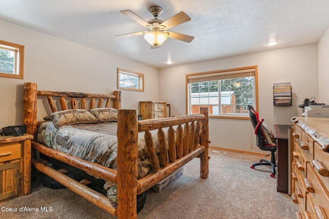 bedroom with light carpet, ceiling fan, and a textured ceiling