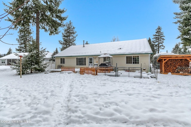 snow covered back of property featuring a deck