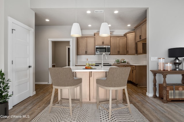 kitchen featuring tasteful backsplash, decorative light fixtures, and light hardwood / wood-style floors