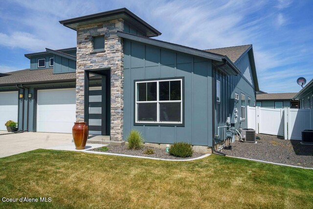 7257 Breaux Dr, Coeur Dalene, ID 83815 - view of front facade with board and batten siding, concrete driveway, central AC, and a garage